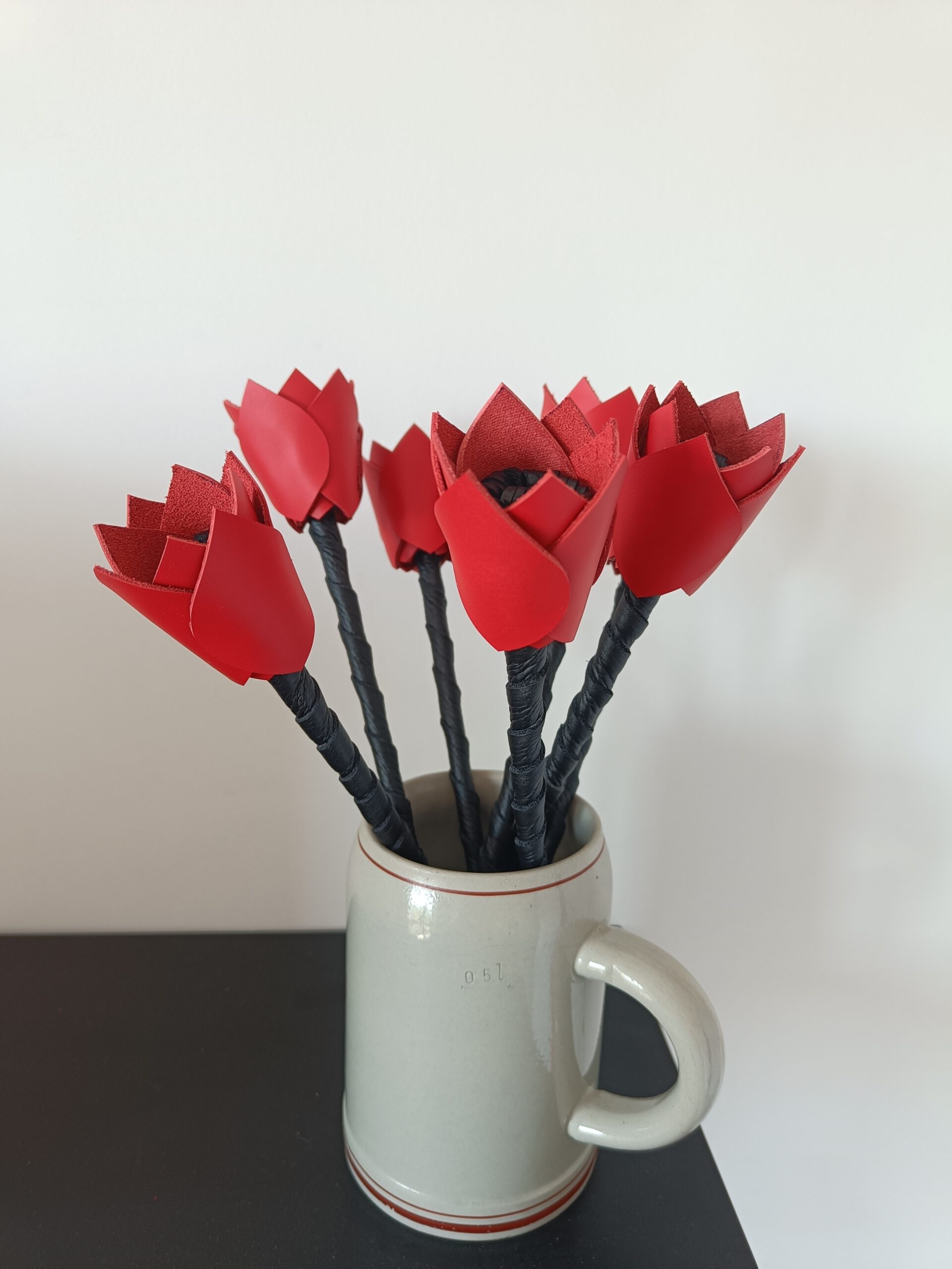Bouquet de fleurs en cuir rouge et noir upcyclé, fait main en France. Dans un vase tasse