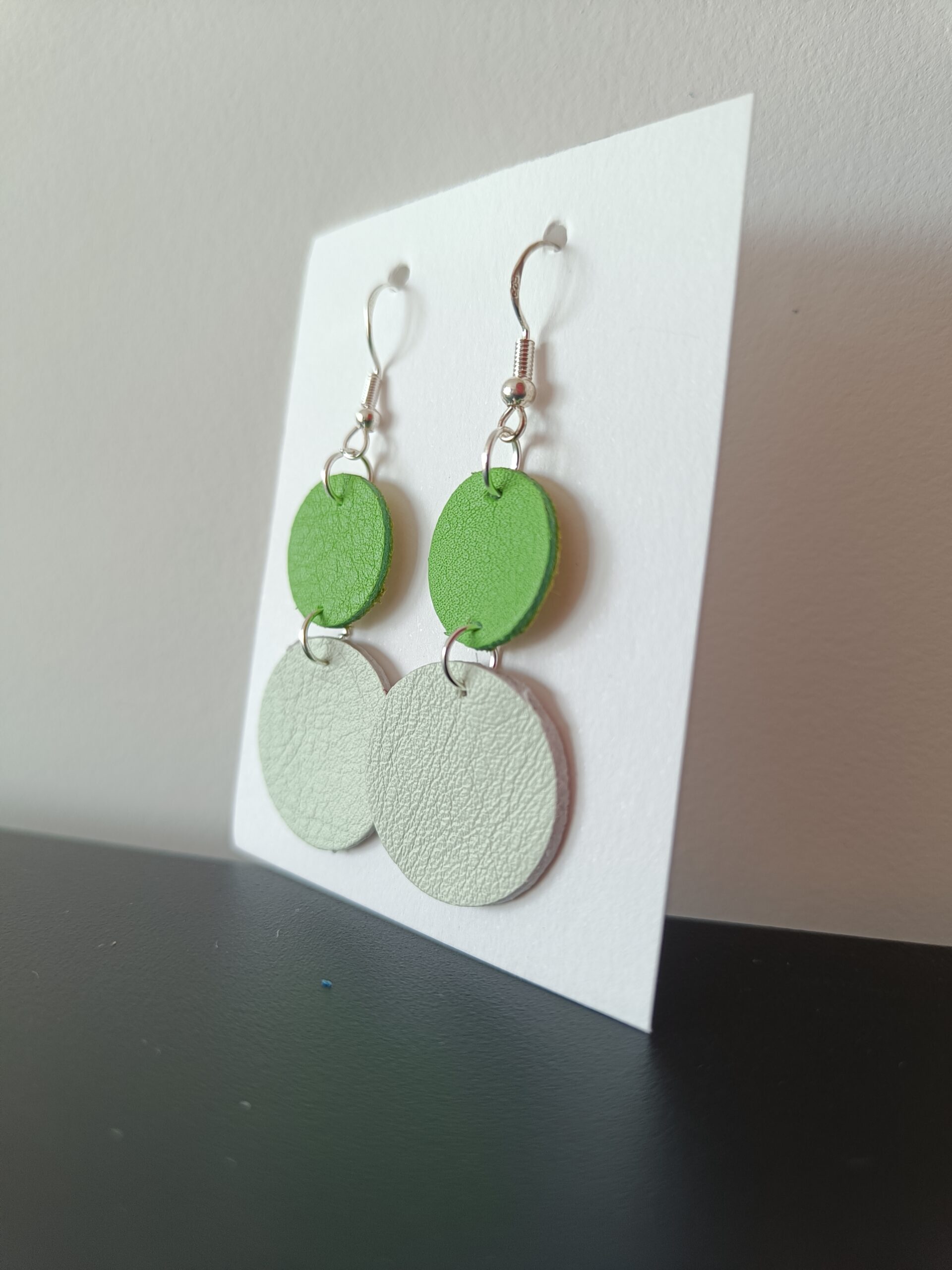 Boucles d'oreilles vert clair et beige en cuir upcyclé fabriquées à la main en France, vue de profil
