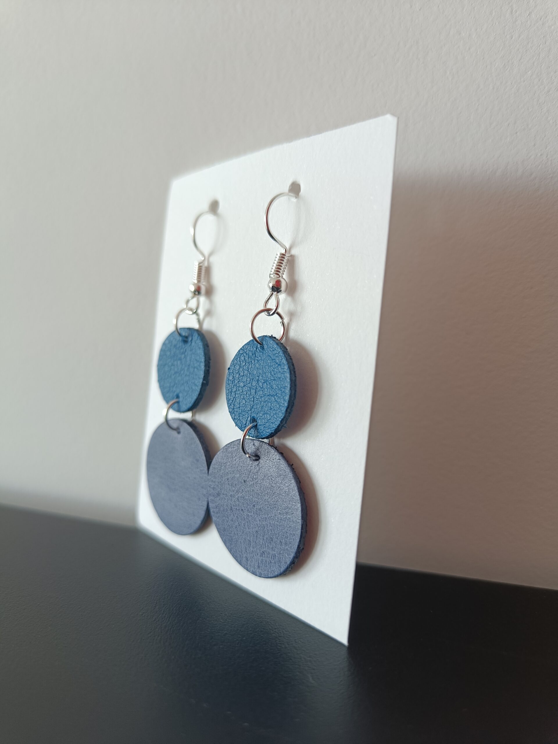 Boucles d'oreilles nuances de bleu argent en cuir upcyclé fabriquées à la main en France, de profil